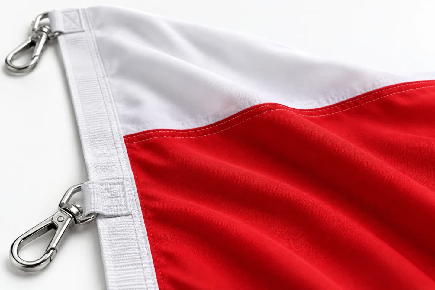 Detail látky bílo-červené vlajky, obšití a pásky s kovovou karabinou — ukázkové ušití